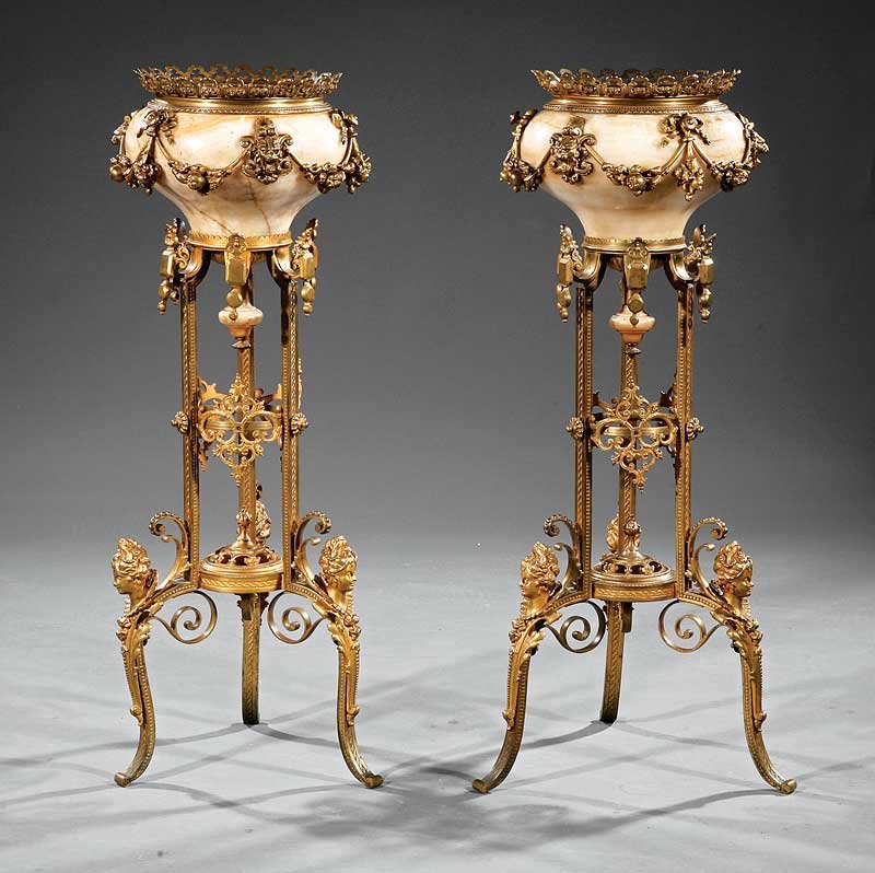 Gilt Bronze and Alabaster Jardinieres on Stands: A Pair of Continental Gilt Bronze and Alabaster Jardinieres on Stands, late 19th c., reticulated rims, the vessels with fruit swags, raised on tripartite stands, the legs mounted with busts of court l