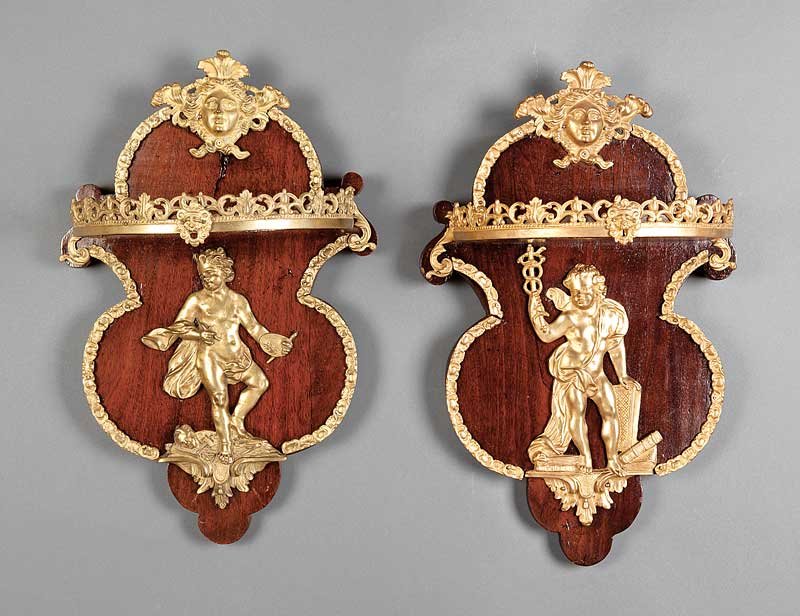 Gilt Bronze-Mounted Mahogany Wall Brackets: A Pair of Louis XVI-Style Gilt Bronze-Mounted Mahogany Wall Brackets, each with mask crest, shelf with reticulated scrolled gallery, shaped back with allegorical putto, height 24 in., width 13 in., de