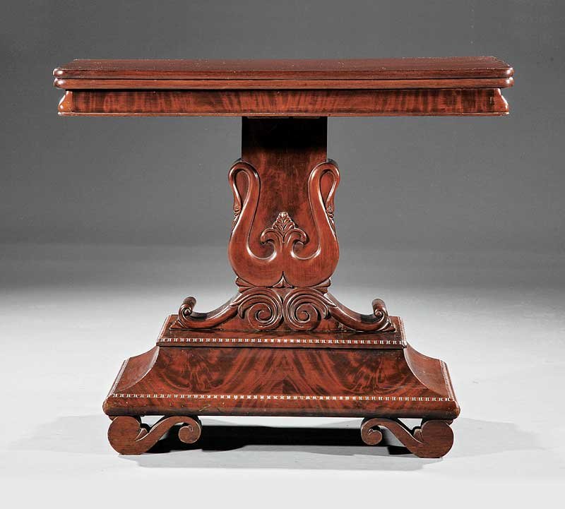 An American Late Classical Mahogany Games Table: An American Late Classical Mahogany Games Table, early 19th c., foldover top, molded frieze, lyre form pedestal on egg and dart plinth base, scrolled feet, casters, height 30 1/2 in., width 36 1/4 in.