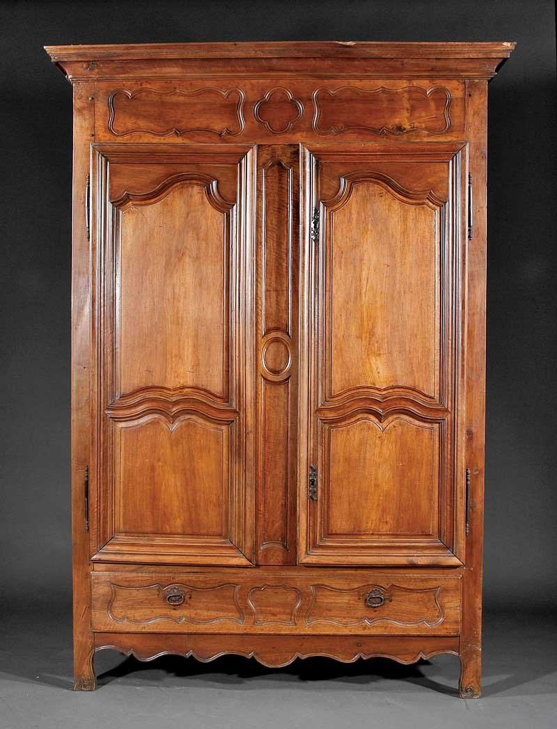 French Provincial Carved Fruitwood Armoire: An Antique French Provincial Carved Fruitwood Armoire, molded cornice, frieze with shaped panels over paired paneled doors with fiche hinges, shelf interior with belt of drawers, long drawer below, sc