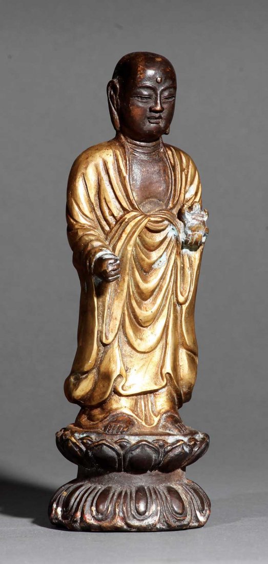 A Chinese Bronze Figure of a Buddhist Monk: A Chinese Bronze Figure of a Buddhist Monk, probably late 19th c., modeled wearing loose robes standing on a double lotus base, height 8 7/8 in