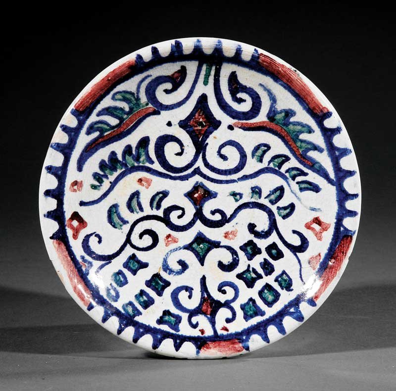 A Shearwater Pottery Plate: A Shearwater Pottery Plate, c. 1950s, decorated by Walter Anderson with a stylized plant design, cobalt blue, green, mulberry and white glaze, impressed mark, diameter 6 in