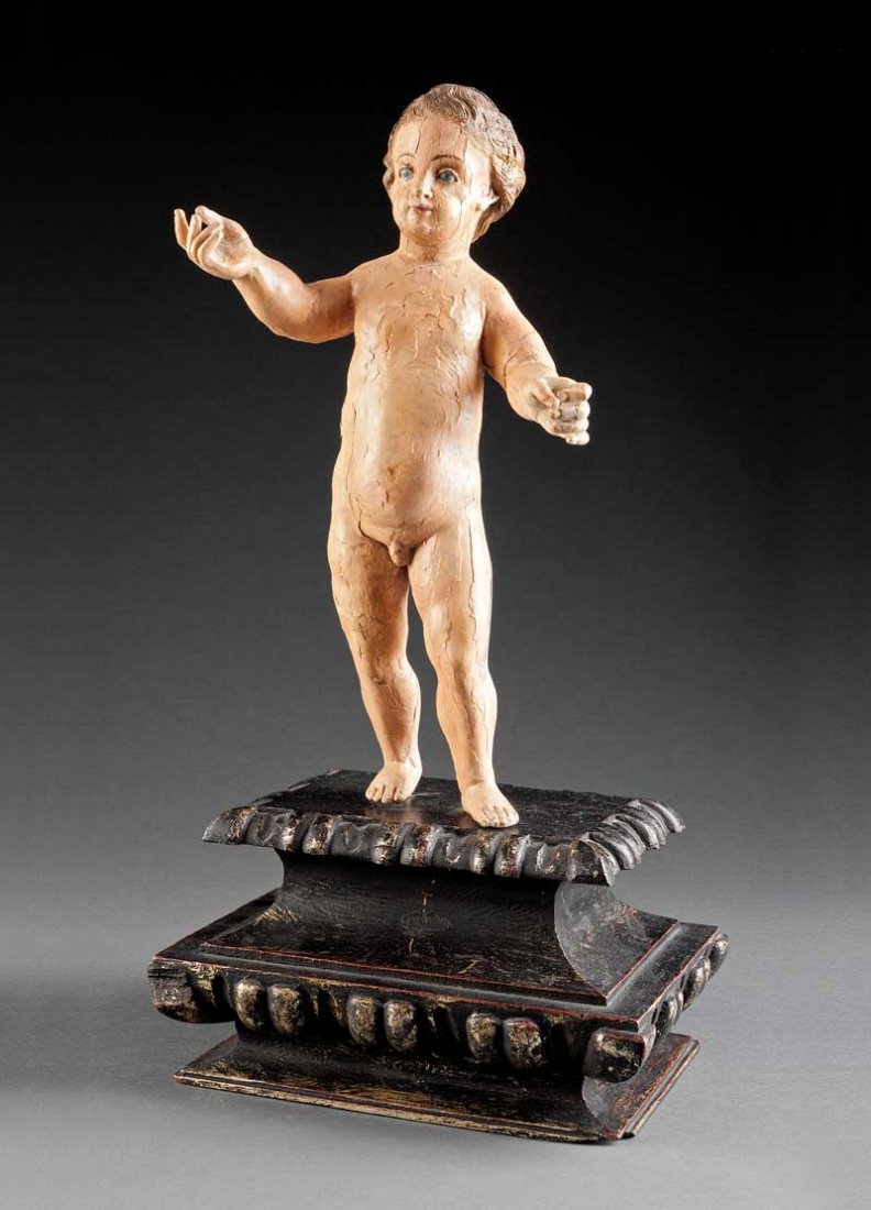 Polychromed Wood Figure of the Christ Child: An Antique Spanish Colonial Polychromed Wood Figure of the Christ Child, carved as a standing figure with outstretched arms, height 17 in., on a molded black and gold pedestal, overall height 24 in . 