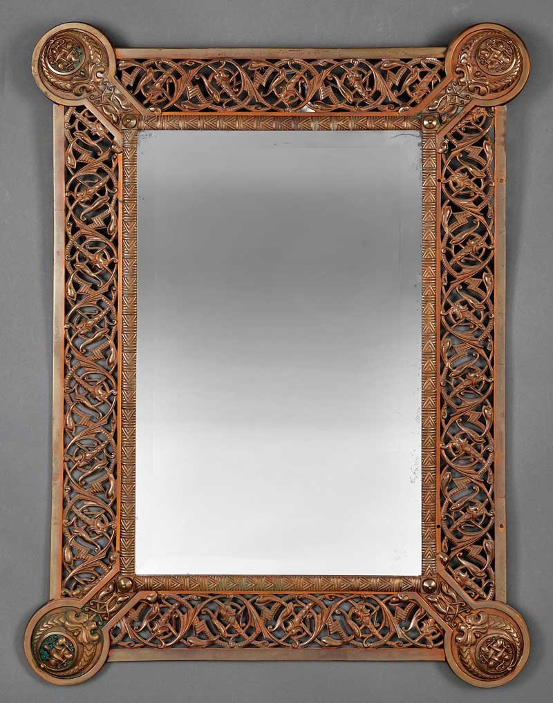 An American or English Aesthetic Bronze Mirror: An American or English Aesthetic Bronze Mirror, with scrolled Celtic motif, rounded domed corners, bears partial paper label, probably for Bailey, Banks & Biddle, Philadelphia, height 40 in., width 30