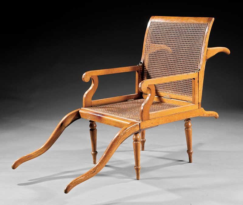 An English Beechwood Campaign Chair: An English Beechwood Campaign Chair, late 19th c., partial label of John Ward, London, caned back and seat, turned legs Note: John Ward and subsequently John Ward, Ltd. were in operation from around 1