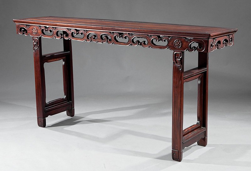 A Chinese Carved Hardwood Altar Table: A Chinese Carved Hardwood Altar Table, inset paneled top, openwork scrolled frieze, trestle base, square volute feet, height 40 1/2 in., width 82 1/4 in., depth 19 1/2 in. Provenance: Estate of Ursula