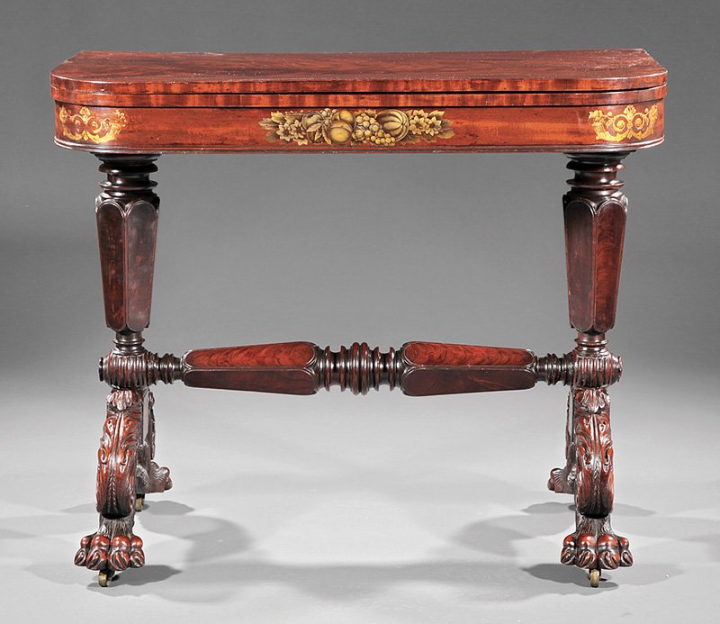 Gilt-Stenciled and Carved Mahogany Games Table: An American Classical Gilt-Stenciled and Carved Mahogany Games Table, c. 1825, New York, foldover top with rounded corners, trestle support with hexagonal columns, acanthus scrolled legs, hairy paw fe