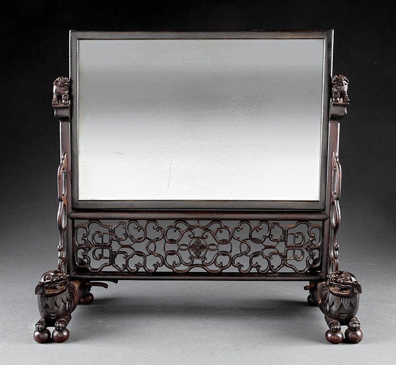 A Chinese Carved Hardwood Dressing Mirror: A Chinese Carved Hardwood Dressing Mirror, rectangular mirror plate, trestle support with lion finials and reticulated crossbar, lion feet, height 20 3/4 in., width 21 in., depth 8 in