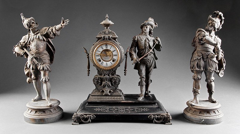 Metal Three Piece Clock Garniture, Ansonia: An American Patinated Metal Three Piece Clock Garniture, c. 1890, Ansonia Clock Co., in the Renaissance style, the figures depicting a cavalier and men in armor, clock height 21 in., width 19 in., dep
