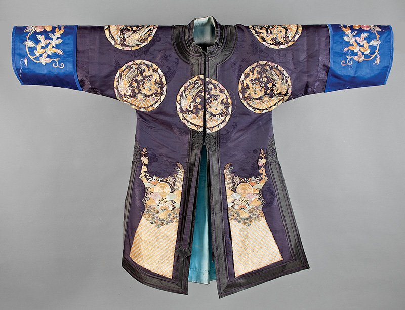 A Chinese Applied Blue Silk Surcoat: A Chinese Applied Blue Silk Surcoat, probably 20th c., worked in couched metallic threads with applied dragon and phoenix roundels, length 36 in