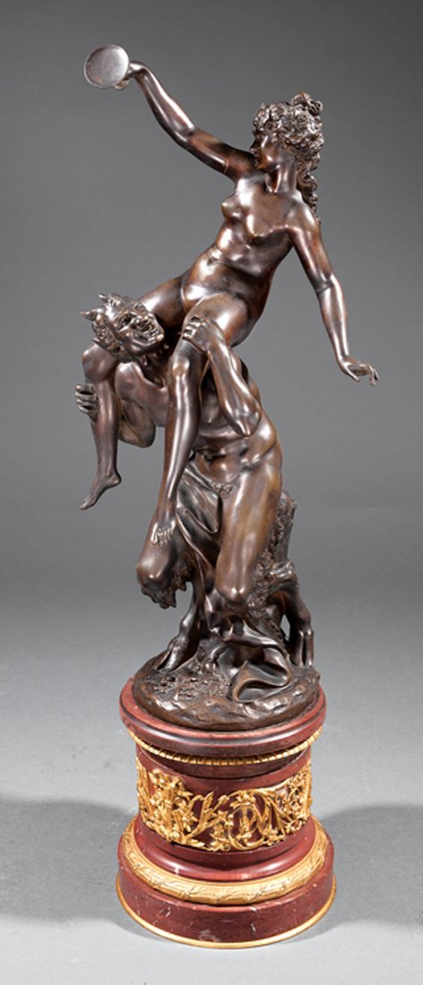 A Continental Bronze Bacchanal Figural Group: A Continental Bronze Bacchanal Figural Group, early 19th c., bacchante atop the shoulders of a satyr, inscribed "Clodion" on base, gilt bronze mounted marble pedestal, overall height 30 in. Provenance