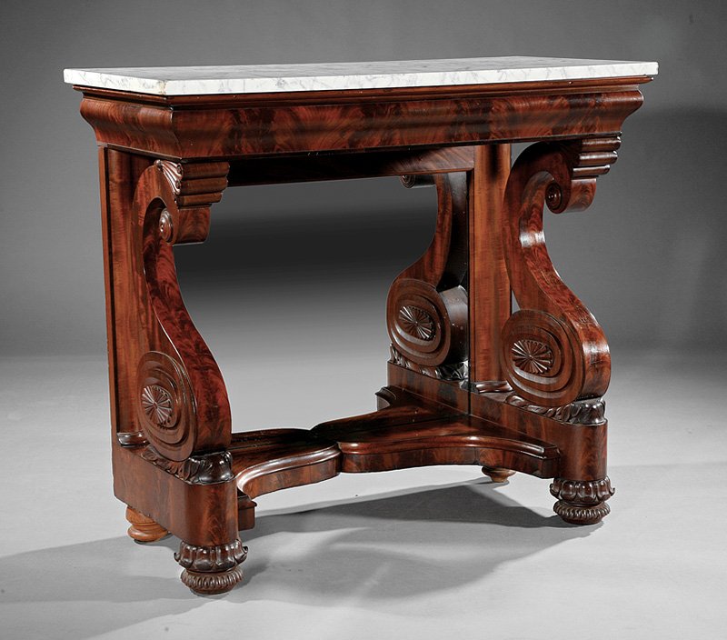 American Classical Carved Mahogany Pier Table: A Fine American Classical Carved Mahogany Pier Table, c. 1825, Philadelphia, marble top, ogee frieze, anthemion carved scroll supports with patera carved oval bosses, mirrored back, cupid's bow plinth