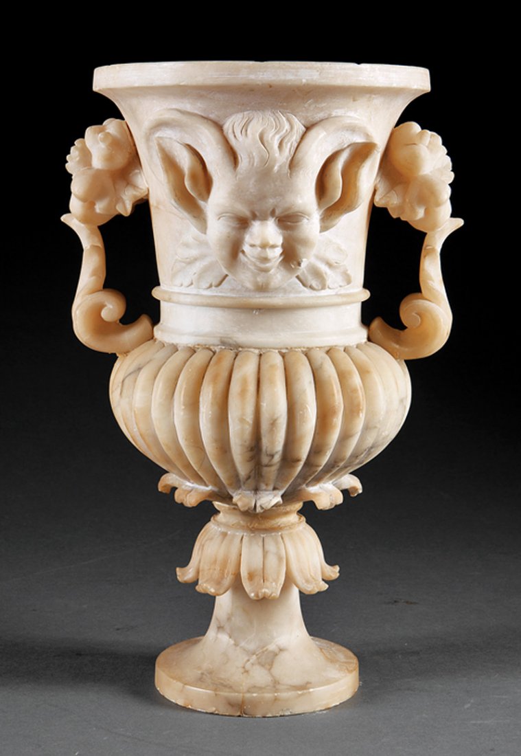 An Italian Alabaster Urn: An Italian Alabaster Urn, c. 1870, floral handles, centered by a grotesque mask, lobed body, height 15 in., diameter 8 in. Provenance: "Villa Rose" Collection of Grace Collins Lindblom, Orlando, FL