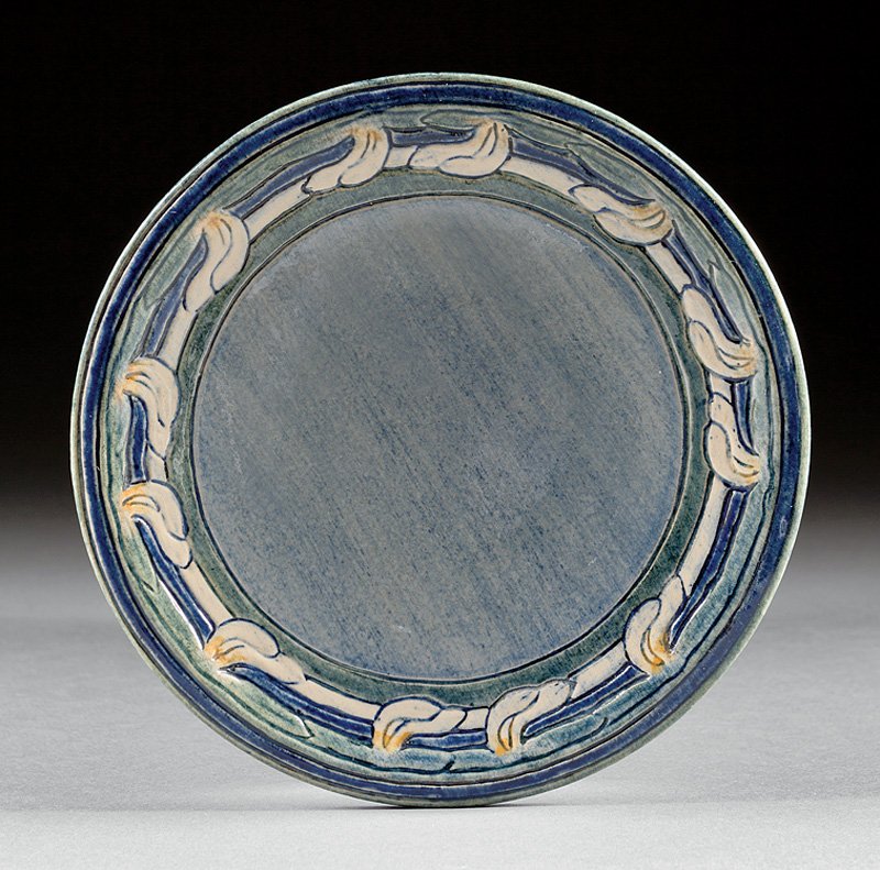 A Newcomb College Art Pottery High Glaze Plate: A Newcomb College Art Pottery High Glaze Plate, 1909, decorated by Marie de Hoa LeBlanc with a maple wing motif, blue, green and yellow underglaze, base marked with Newcomb cipher, decorator's mark, J
