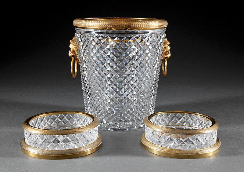Gilt Bronze-Mounted Cut Crystal Wine Cooler: A Continental Gilt Bronze-Mounted Cut Crystal Wine Cooler, engine-turned rim, lion mask handles, diamond point pattern, height 9 1/8 in.; together with two bronze-mounted cut crystal wine coasters, (3