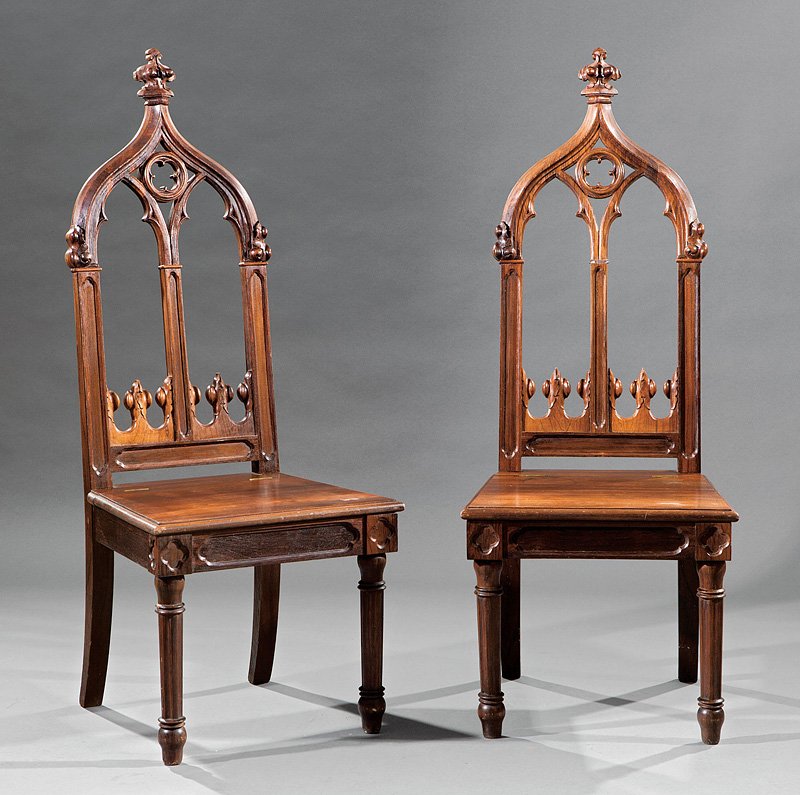 A Pair of American Gothic Rosewood Hall Chairs: A Pair of American Gothic Rosewood Hall Chairs, mid-19th c., arched crocketed crest, quatrefoil carved back, paneled stiles, trapezoidal lift seat, conforming seat rail, fluted tapered turned legs