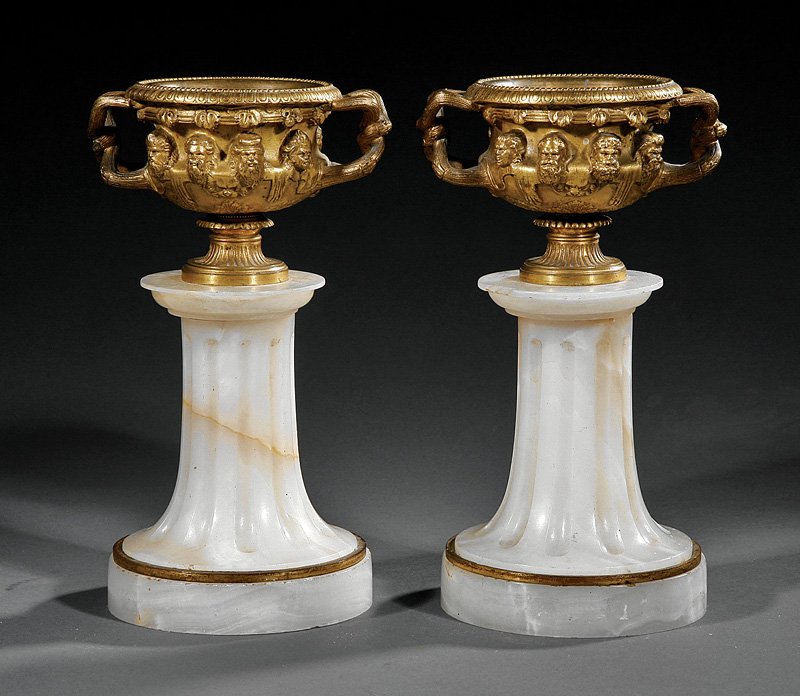 A Pair of Gilt Bronze Warwick Vases: A Pair of Small Antique Gilt Bronze Warwick Vases, raised on fluted marble and bronze-mounted pedestals, height 9 in., diameter 5 1/4 in