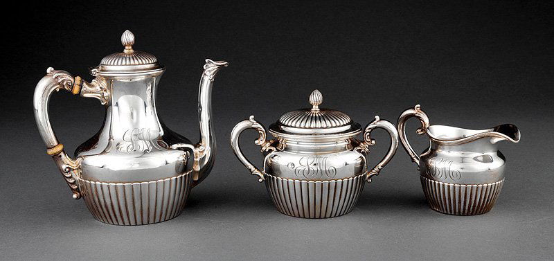 A Gorham Sterling Silver Tea Set: A Gorham Sterling Silver Tea Set, date mark for 1896 and 1900, comprised of a teapot, covered sugar and creamer, each with reeding and scroll handles, teapot height 7 3/4 in., combined weight 37.90 tr