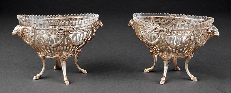 Silver and Glass Garniture Coupes: A Pair of Continental Silver and Glass Garniture Coupes in the Neoclassical Taste, hallmarked, marks not traced; reticulated oval frames decorated with bowknots and rams' heads, hoof feet, height 4 1/