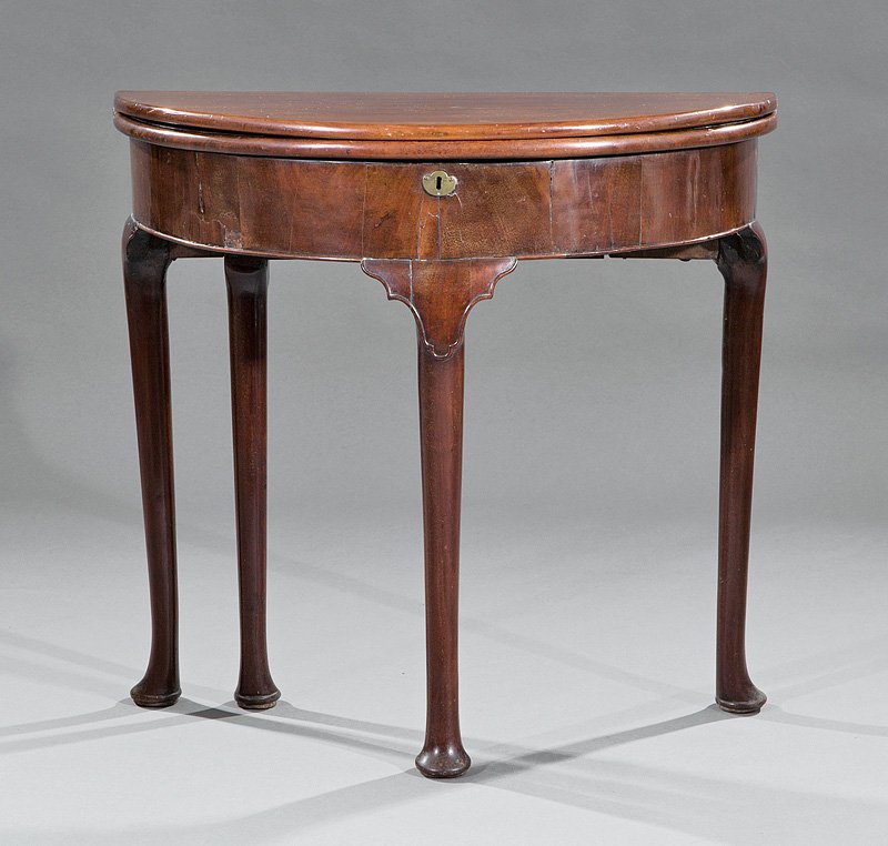 A George III Mahogany Demilune Games Table: A Small George III Mahogany Demilune Games Table, 18th c., fold over top, with carved pockets, open well, cabriole legs, pad feet, height 28 3/8 in., width 29 3/4 in., depth 14 1/2 in