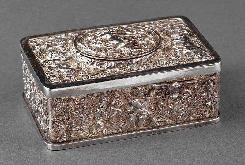Repousse Silverplate Singing Bird Automaton: Continental Repousse Silverplate Singing Bird Automaton, late 19th/early 20th c., rectangular body relief-decorated with putti and birds on a scrollwork ground, oval hinged lid opening to singing bird