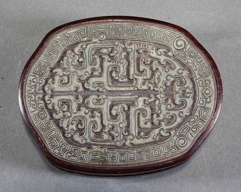 Chinese Hardwood Case: Chinese Carved Stone Inkstone and Stone-Inset Hardwood Case, probably 19th/20th c., probably Duan stone, oval greenish stone carved with archaistic flanges, reverse incised, set in a brown stone base;