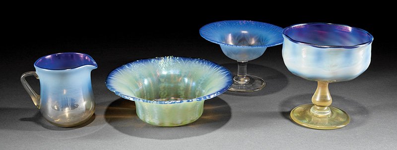 Tiffany Favrile Blue Pastel Glass Table Articles: Four Tiffany Favrile Blue Pastel Glass Table Articles, each marked, incl. compote, paper label; bowl; sherbet dish; and cream pitcher; tallest h. 4 3/8 in. Provenance: New Orleans Estate
