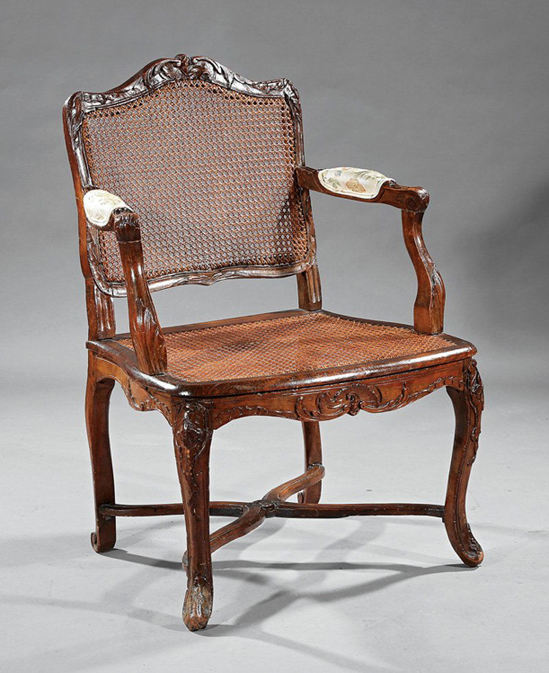 Louis XV Carved Fruitwood Fauteuil: Louis XV Carved Fruitwood Fauteuil, 18th c., arched foliate crest, padded acanthus scrolled arms, caned back and seat, foliate carved cabriole legs, molded X stretcher. Provenance: New Orleans Estate