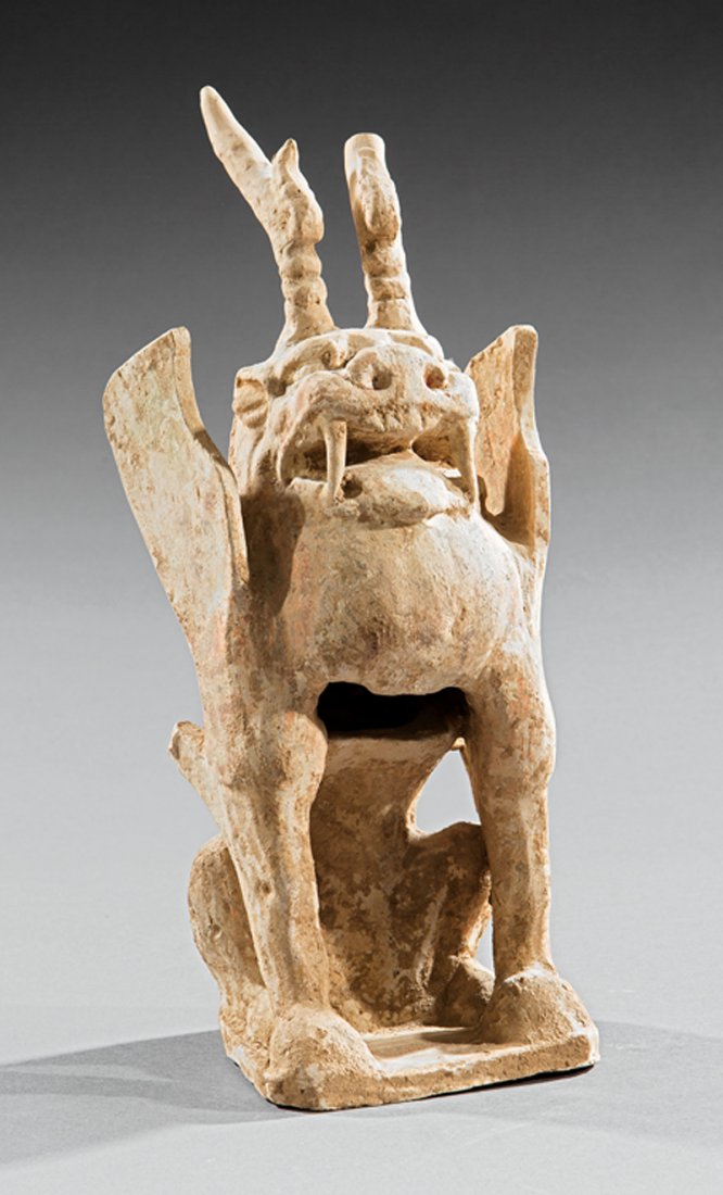 Chinese Pottery Figure of a Guardian Beast: Chinese Pottery Figure of a Guardian Beast, probably Tang Dynasty (618-906), modeled with horns and folded wings seated on its haunches, h. 14 7/8 in. Provenance: accompanied by a copy of the New Orle