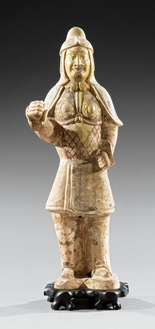 Chinese Pottery Figure of a Warrior: Chinese Pottery Figure of a Warrior, probably Tang Dynasty (618-907), standing in armor and helmet with one raised arm, h. 18 1/2 in., wood stand, overall h. 19 1/2 in. Provenance: New Orleans Estate