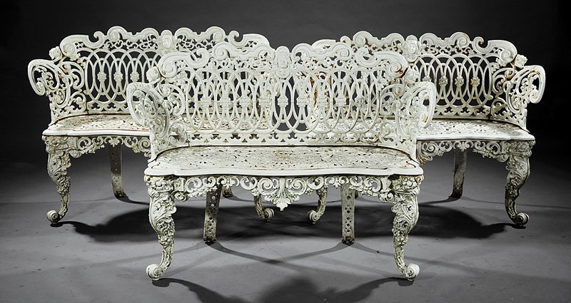 Three American Cast Iron Settees: Three American Cast Iron Settees, c. 1900, in the "Renaissance Scroll" design, intertwined back with bust cartouche, scrolled arms, serpentine seat rail, Gothicized pierced seat, fruit and acanthus ca