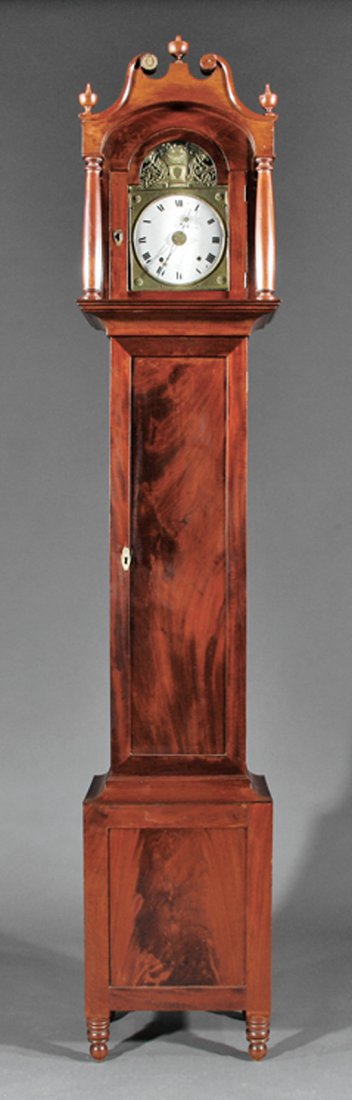 American Carved Mahogany Tall Case Clock: American Carved Mahogany Tall Case Clock, early 19th c., Mid-Atlantic, bonnet with broken arch crest, tapered columns flanking face, antique Morbier movement, paneled door, cove molded base, turned fe