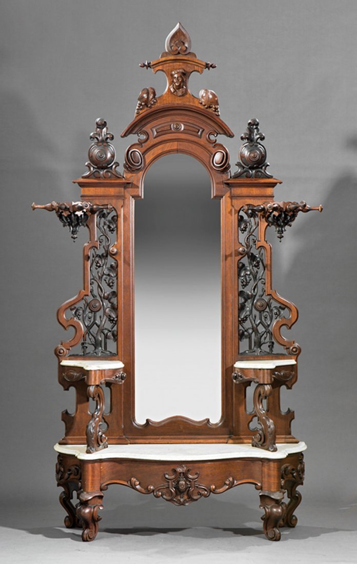 American Renaissance Carved Walnut Hallstand: American Renaissance Carved Walnut Hallstand, mid-19th c., possibly Mitchell and Rammelsberg, Cincinnati, anthemion crest with male bust, arched mirror plate flanked by reticulated grapevine panels, s