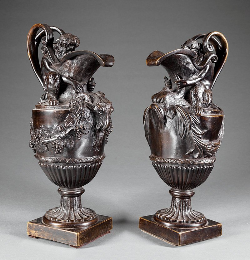 Continental Neoclassical-Style Bronze Ewers: Pair of Continental Neoclassical-Style Bronze "Water and Wine" Ewers, 19th/20th c., after the model by John Flaxman (British, 1755-1826), one surmounted by the figure of Triton, the other by Bacchus, 