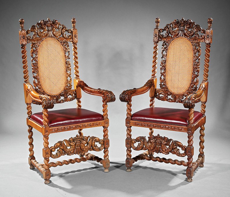 Jacobean-Style Carved Walnut and Caned Armchairs: Pair of Jacobean-Style Carved Walnut and Caned Armchairs, late 19th c., each with pierced foliate and cherub crest, barley-twist stiles, scrolled arms, drop-in leather seat, foliate and cherub front s