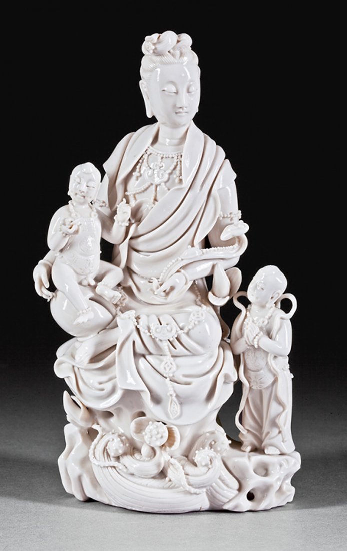 Chinese "Blanc de Chine" Porcelain Guanyin: Chinese "Blanc de Chine" Porcelain Figural Group of Guanyin, probably Qing Dynasty (1644-1911), intricately modeled holding a child in one arm and a ruyi scepter in the other, seated on a rockwork led