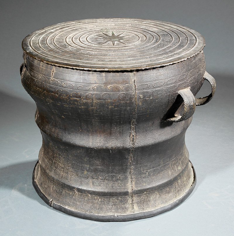 Southeast Asian Bronze Rain Drum: Southeast Asian Bronze Rain Drum, top with central starburst roundel encircled by raised concentric bands, body with pairs of loop handles, h. 13 1/4 in., w. 17 1/4 in