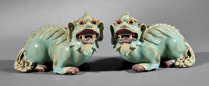 Chinese Biscuit Glazed Pottery Buddhist Lions: Pair of Chinese Biscuit Glazed Pottery Buddhist Lions, probably Qing Dynasty (1644-1911), opposing recumbent figures with pale blue and aubergine glaze, h. 5 in., w. 7 1/2 in
