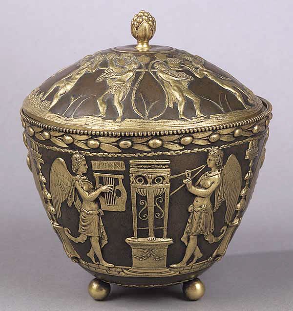 A Gilt and Patinated Bronze Bowl: A Gilt and Patinated Bronze Bowl , the lid with grape finial and encircled with figures harvesting grapes, the bowl with classical scene of angels playing harps and lutes, supported on three ball feet