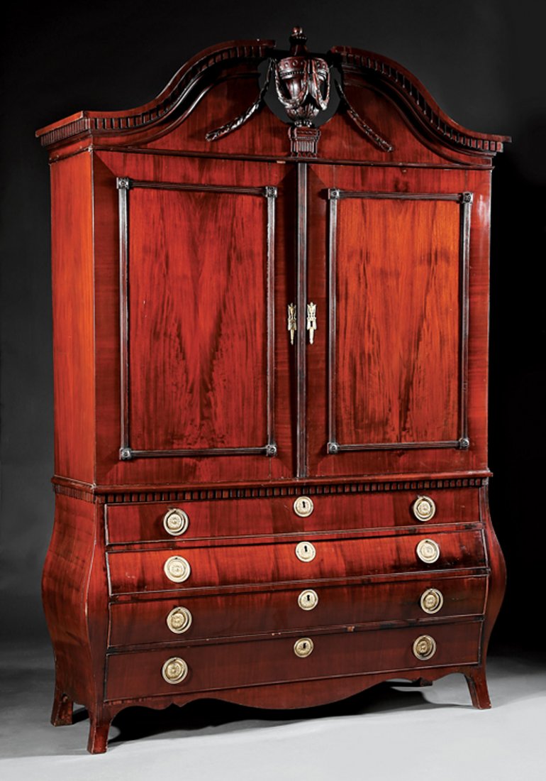 Large Dutch Carved Mahogany Press: Large Dutch Carved Mahogany Press in the Neoclassical Taste, 19th c., broken arch pediment with swags and urn, paneled doors with shelf interior, bombe lower case with four drawers, "French" feet, h. 