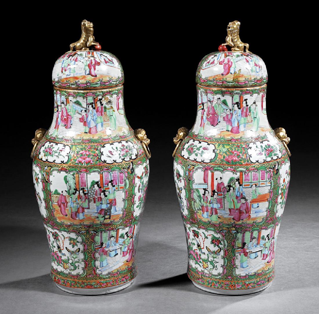 Chinese Export Famille Rose Porcelain Vases: Pair of Chinese Export Famille Rose Porcelain Covered Baluster Vases, mask ring handles, domed lids and Buddhist lion finials, h. 20 in