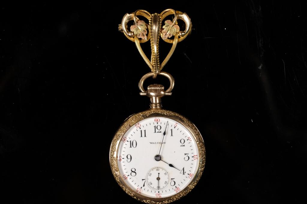 Waltham Ladies Pocket Watch w/Lapel Fob: American Waltham Model 1900 Grade No. 110 ladies pocket watch with fancy lapel fob, Serial No.16957855, 0s, 7j, open face. Back interior cover engraved WADSWORTH/WARRANTED/20 YEARS/1757114,circa 1908.