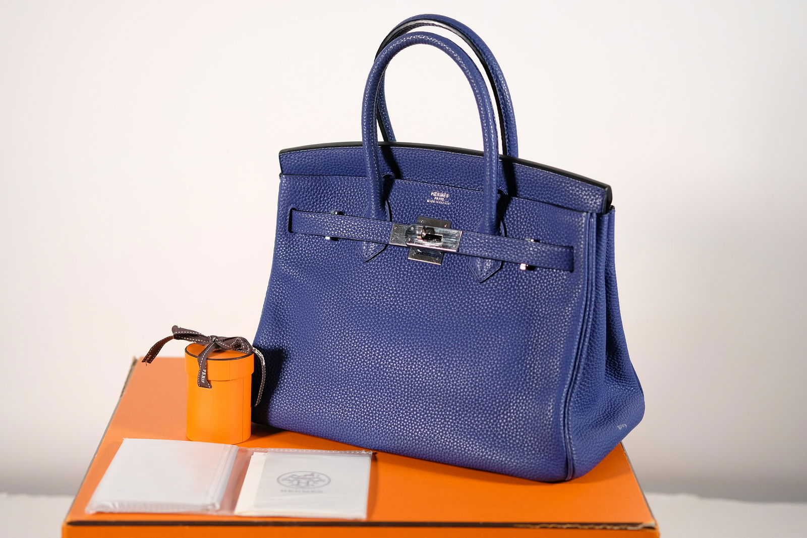 Hermes Birkin 30 Palladium Hardware & Original Box: Hermes Birkin Bag size 30cm with orignal box, palladium hardware, rain jacket, and lock & key. Some minor signs of wear around the bottom corners and hardware. Note, there is a slight stain on the sid