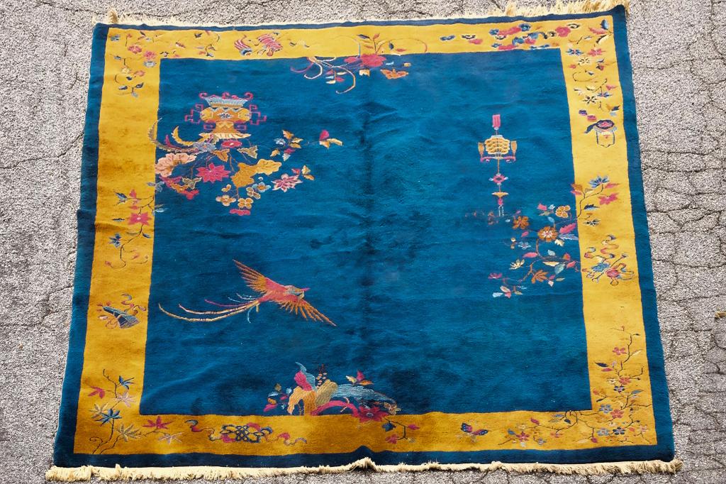Large Art Deco Finely Hand Woven Chinese Rug: Chinese, 1930's. Large art deco style rug, hand woven, indigo blue field decorated with flying phoenix and precious objects, the yellow gold border further decorated with auspicious symbols, bats and 