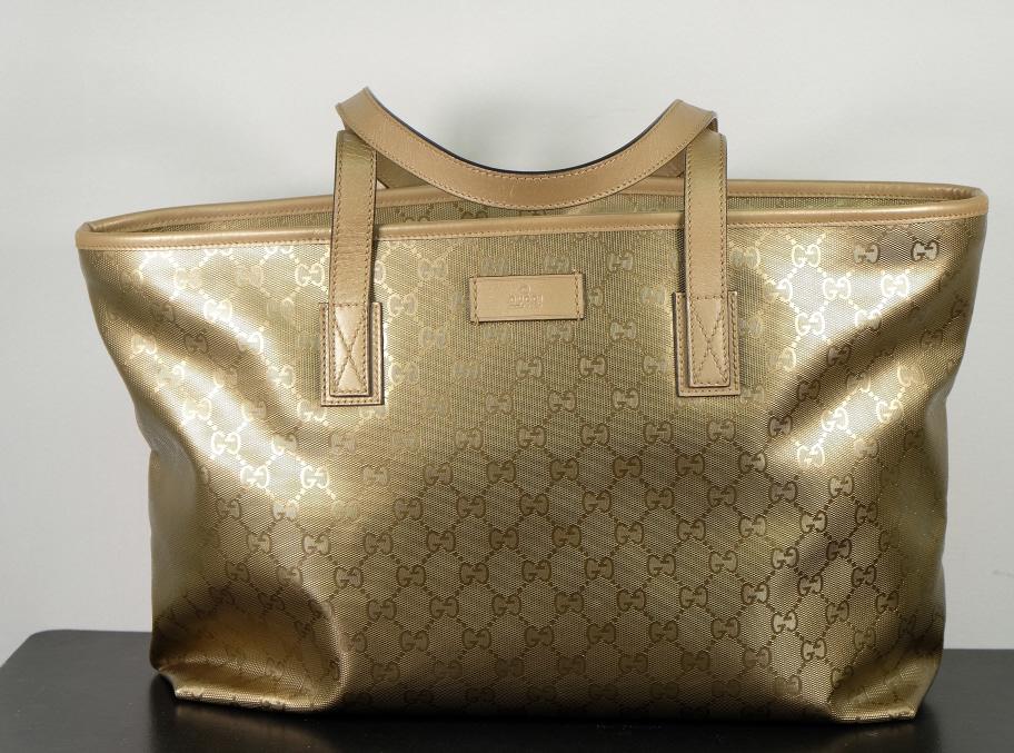 Gold Gucci Monogram Tote Bag: Gucci monogram tote bag in gold. In like new condition. Measures 14.5 inches across 10.5 inches tall and 4.5 inches deep with a 7.25 inch drop.