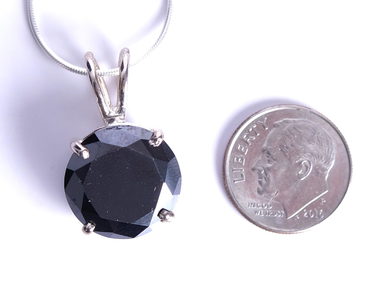 Sterling & 11 CT Black Diamond Pendant Necklace: 11 carat round brilliant cut black diamond solitaire pendant set in sterling silver and hung from a sterling necklace accompanied with Quality Analysis Card. Approx. weight of pendant 4.24 grams. Appr
