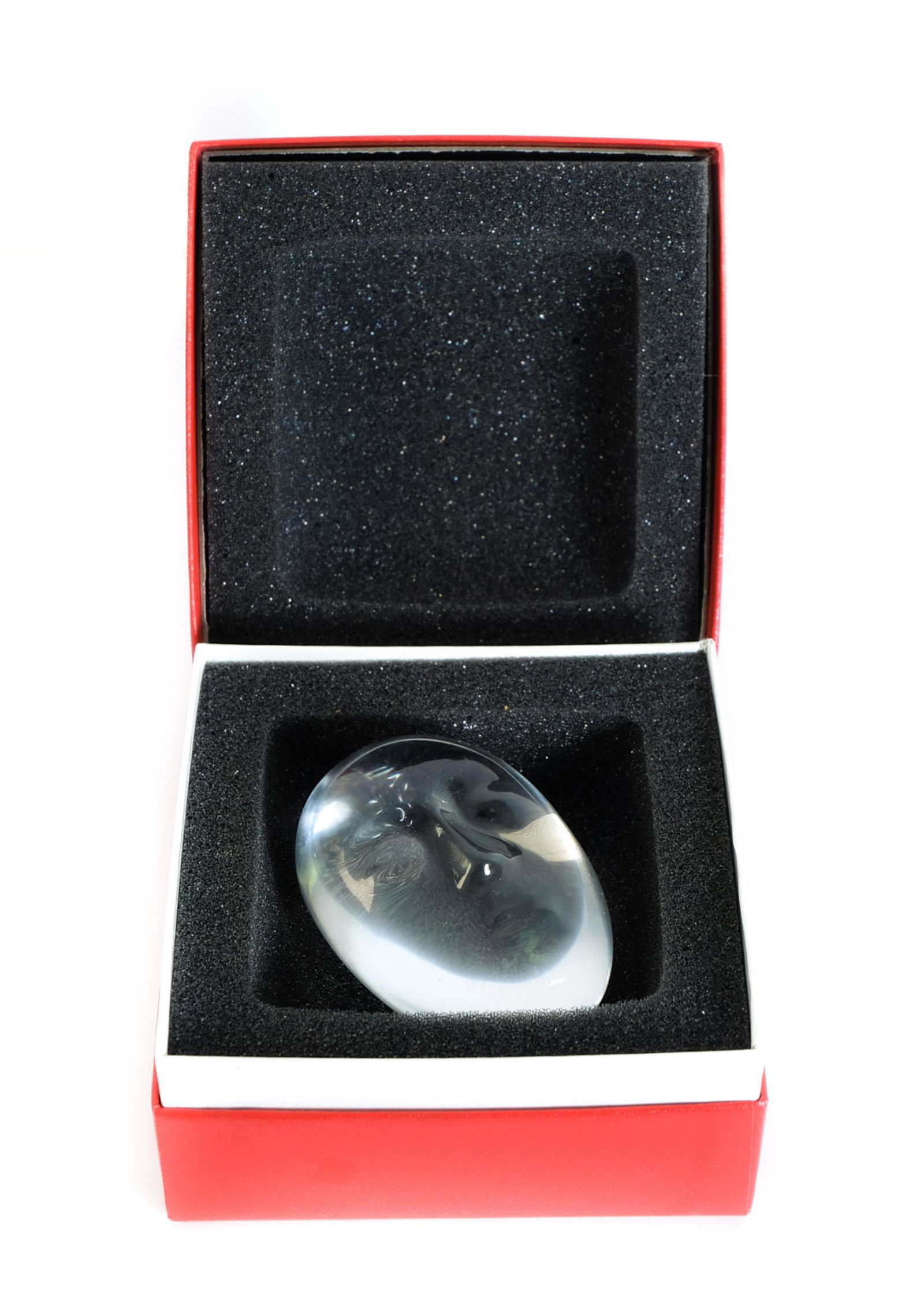Baccarat Crystal Paperweight Tiki Mask w/Box: Baccarat crystal paperweight in egg shape with Tiki mask. Presented in original box. Acid mark for Baccarat. Approx. 3" x 1.75".