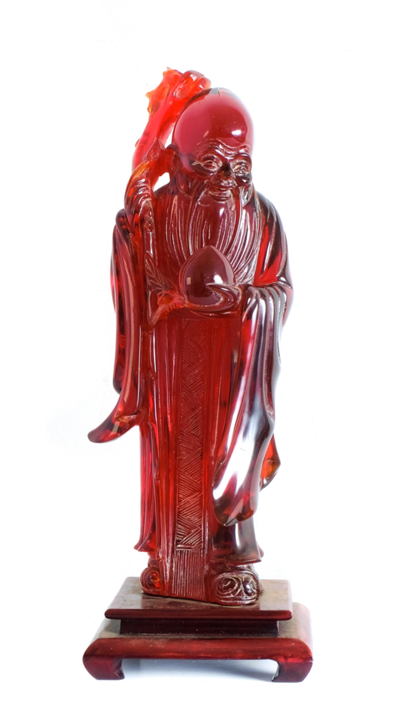 Large Vintage Bakelite Sculpture of Shou Lao: Large and vintage figural sculpture in bakelite depicting figure of Shou Lao, the Chinese god of longevity, holding a staff and a peach. Presented affixed on wood base. Approx. height 14.62", width 6.