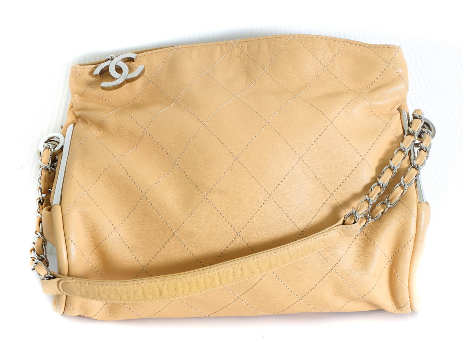 Chanel Quilted Tan Lambskin Purse: Chanel quilted tan lambskin purse with palladium tone hardware and zipper top. Minor signs of wear throughout. Minor pen marks at the top and scuffing at the base. Measures 12.25 inches long, 4 inches