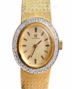 Omega 14k Yellow Gold & Diamond Ladies Watch: Ladies 14k yellow gold Omega watch having a gold dial with baton hour markers, diamond set oval bezel and 14kt yellow gold textured strap. Approx. length 6 in., overall weight 35.5 grams.